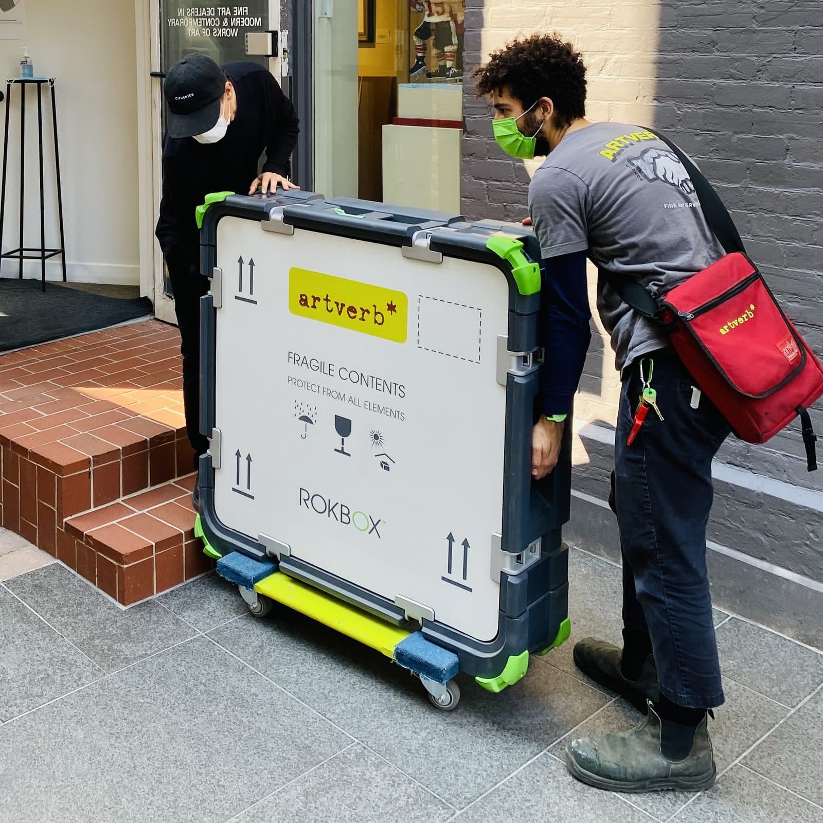 Two crew members wheeling a ROKBOX SMALL on a dolly