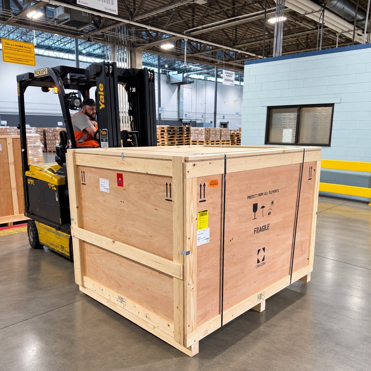 A large export crate in the warehouse with a forklift behind