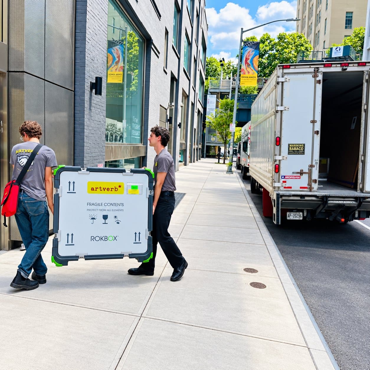 Two handlers carrying a ROKBOX along a city sidewalk to the truck