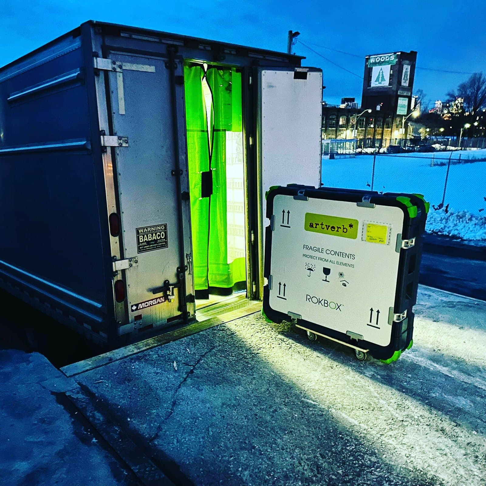 A ROKBOX beside an open ArtVerb truck at night