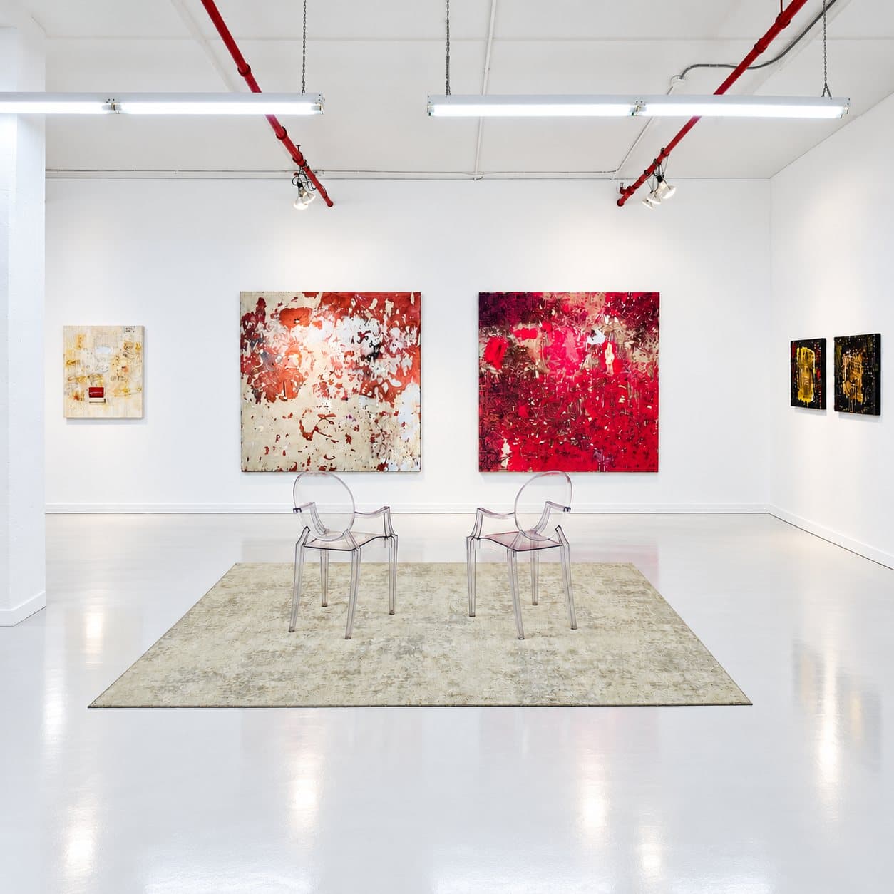 The viewing room: three paintings, two clear chairs, and a rug